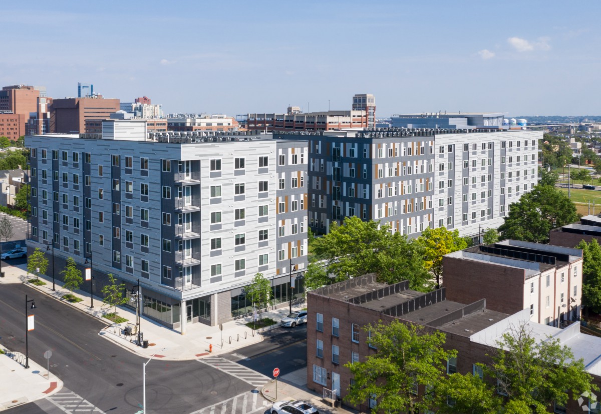A modern residential apartment building in an urban setting, surrounded by streets and greenery.