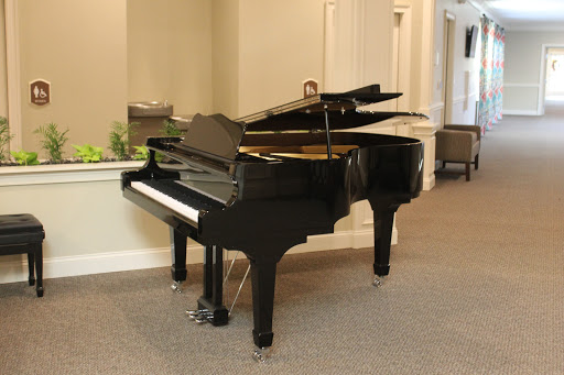A beautiful black grand piano sits elegantly in the spacious interior.
