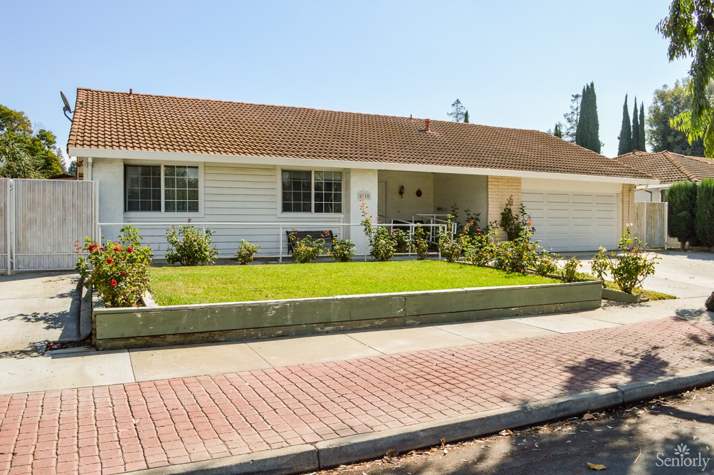 A suburban single-story house with a well-maintained front yard.