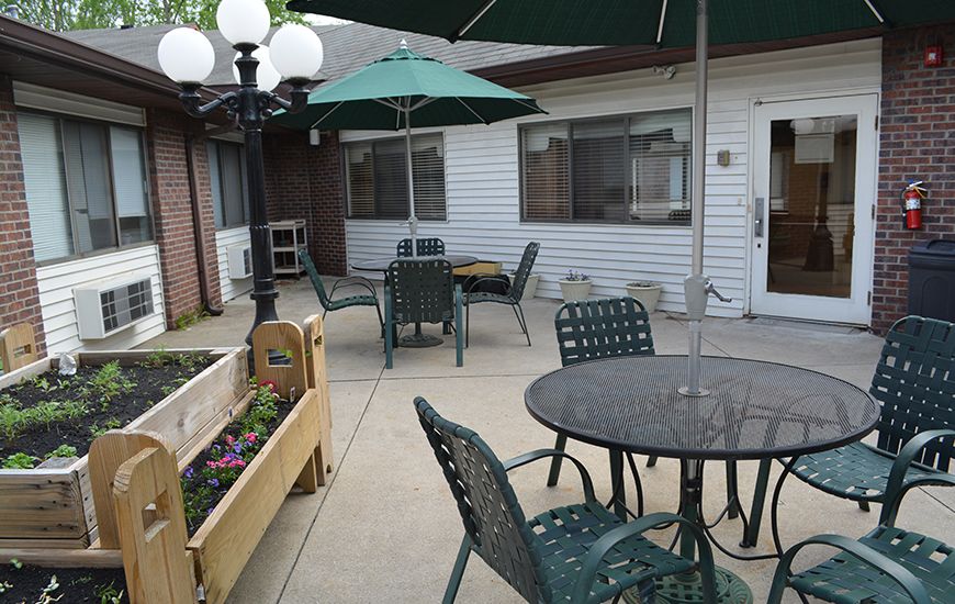 A cozy outdoor patio with tables, chairs, and umbrellas next to a building.
