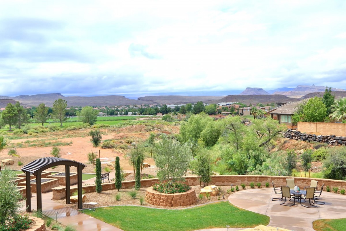 A scenic view of a landscaped garden overlooking a rural landscape with distant hills.