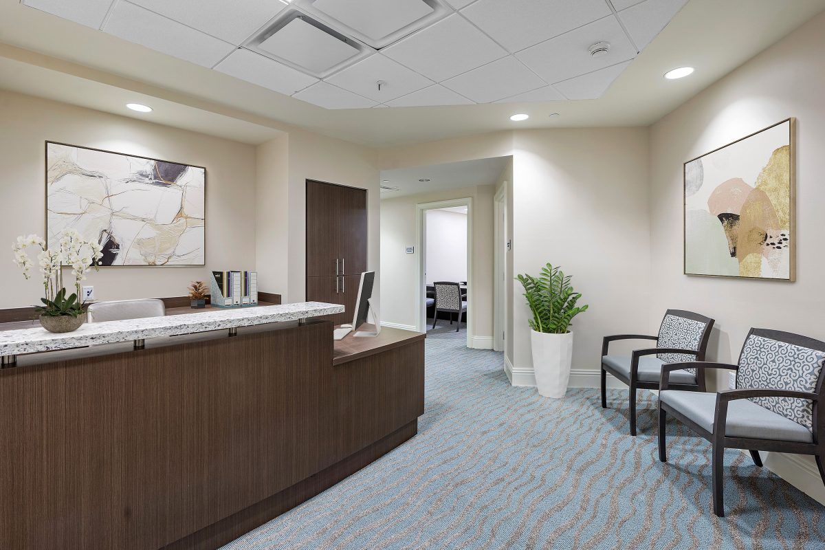 A modern office reception area with seating and a desk.