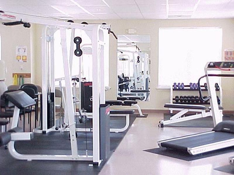 A well-equipped gym with various fitness machines and weights.