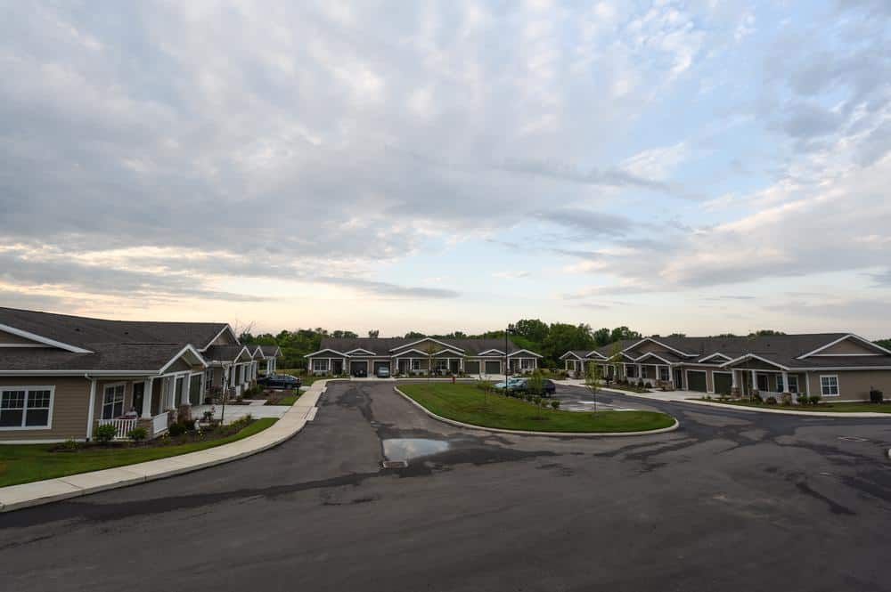 A suburban neighborhood with rows of houses under a cloudy sky.