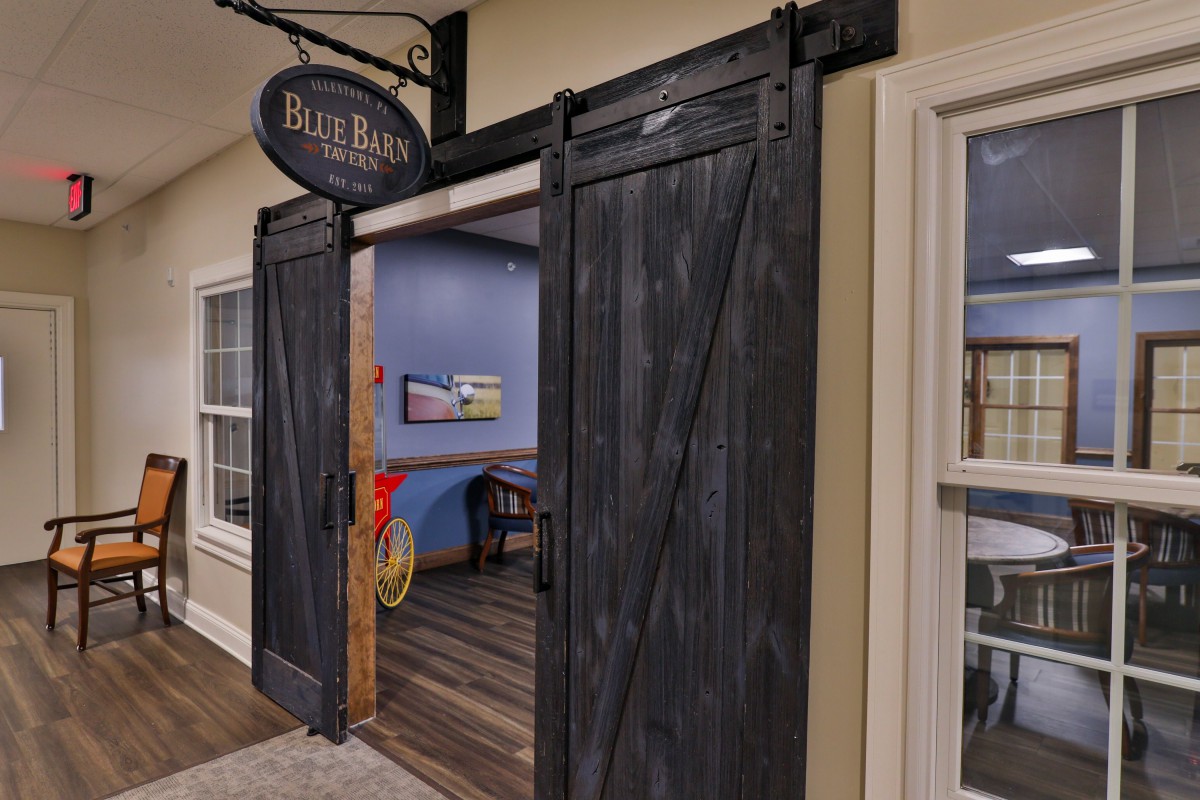 A rustic interior entrance with sliding barn doors leading to a cozy room.