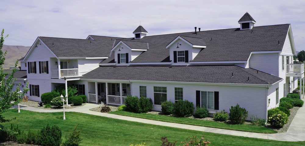 A suburban residential home with a well-maintained lawn and bushes.