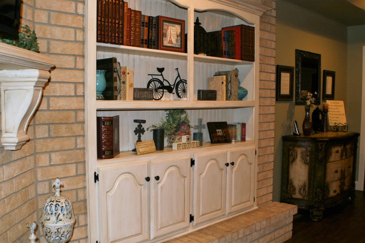 A vintage white bookshelf filled with books and decorative items in a cozy home setting.