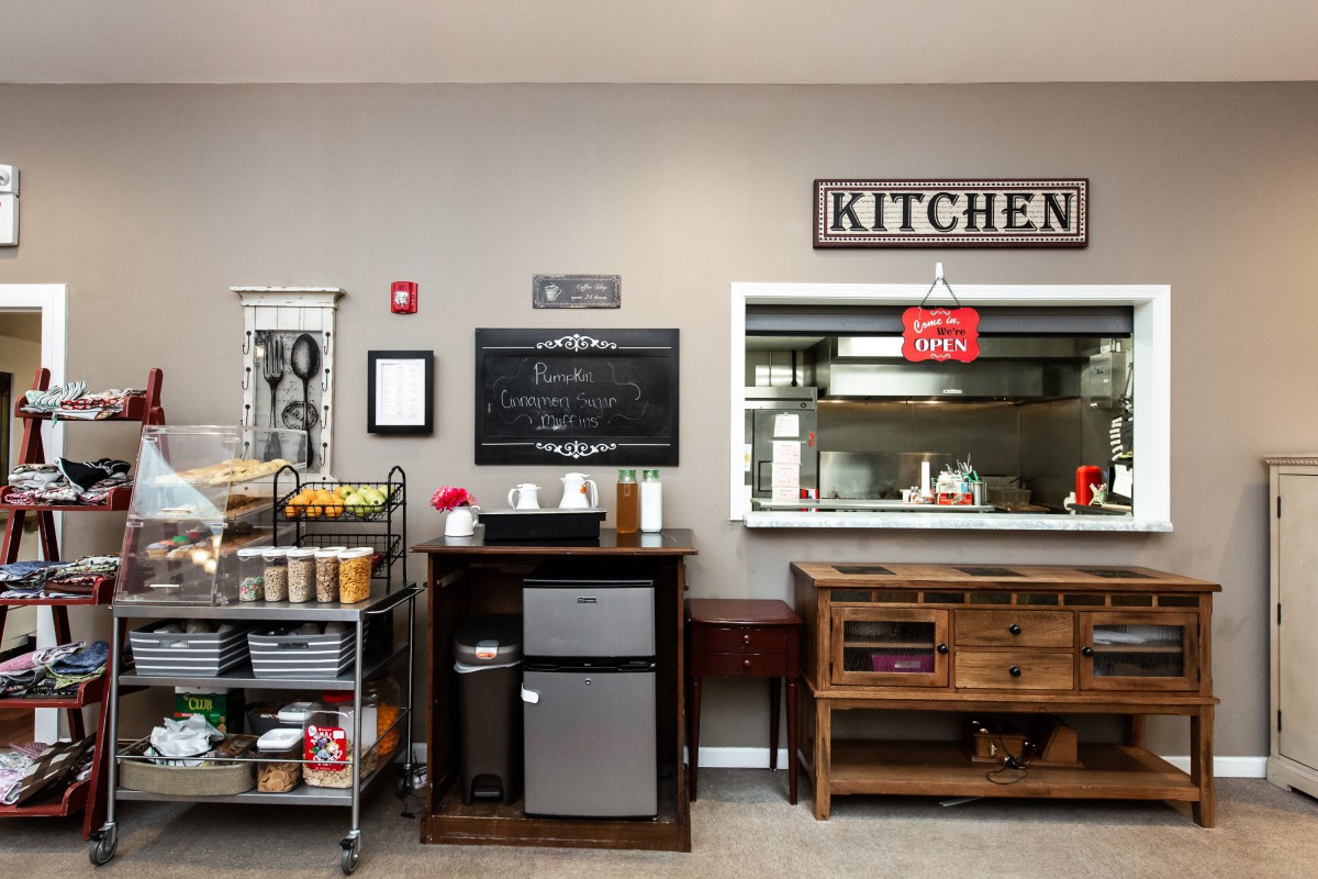 A well-organized kitchen space featuring storage shelves, appliances, and decorative elements.