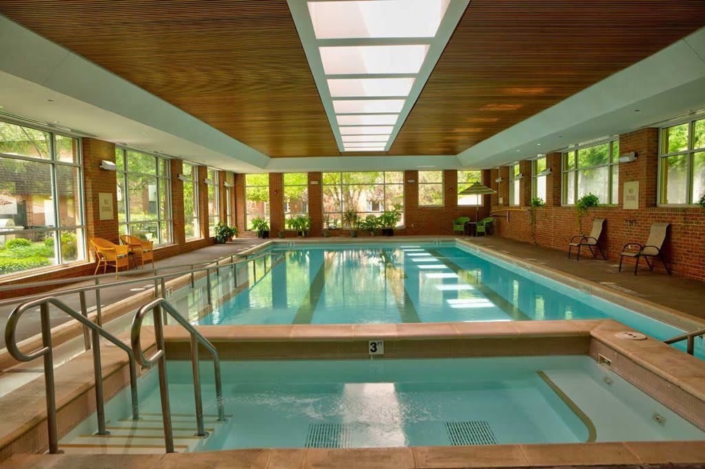 A serene indoor swimming pool with natural lighting and wooden interior.