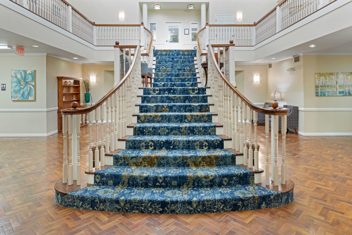 A grand, carpeted staircase in a luxurious interior setting.