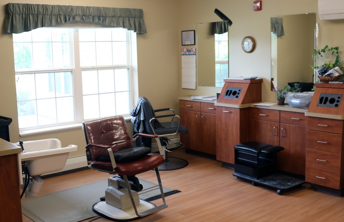 A cozy barbershop interior featuring a classic barber chair and large mirrors.