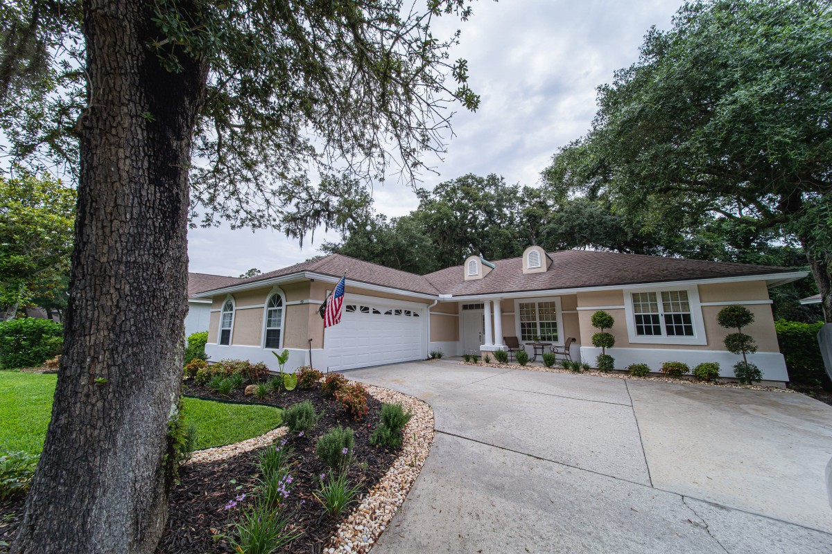 A suburban house with a well-maintained driveway and landscaping.