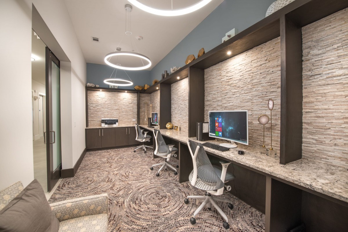 A modern office space with multiple workstations, sleek chairs, and stylish lighting.