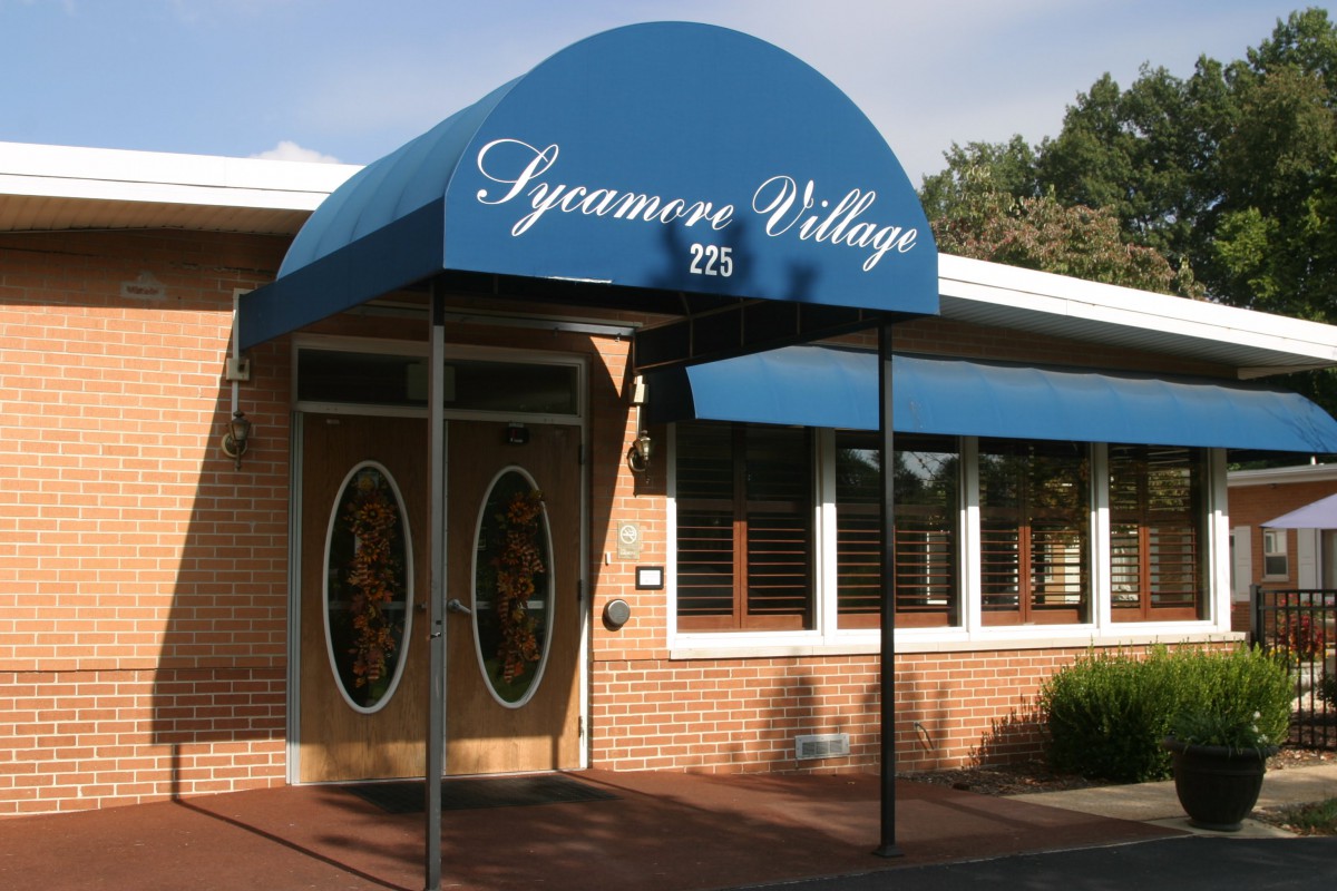 Entrance to Sycamore Village with blue awning.