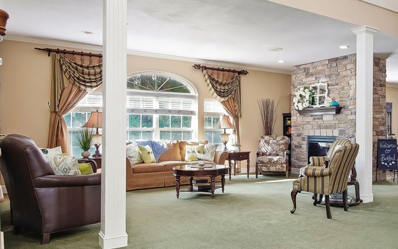 A cozy and elegantly decorated living room with comfortable furniture and a fireplace.