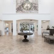 Spacious and elegant lobby with a central round table and chandelier.