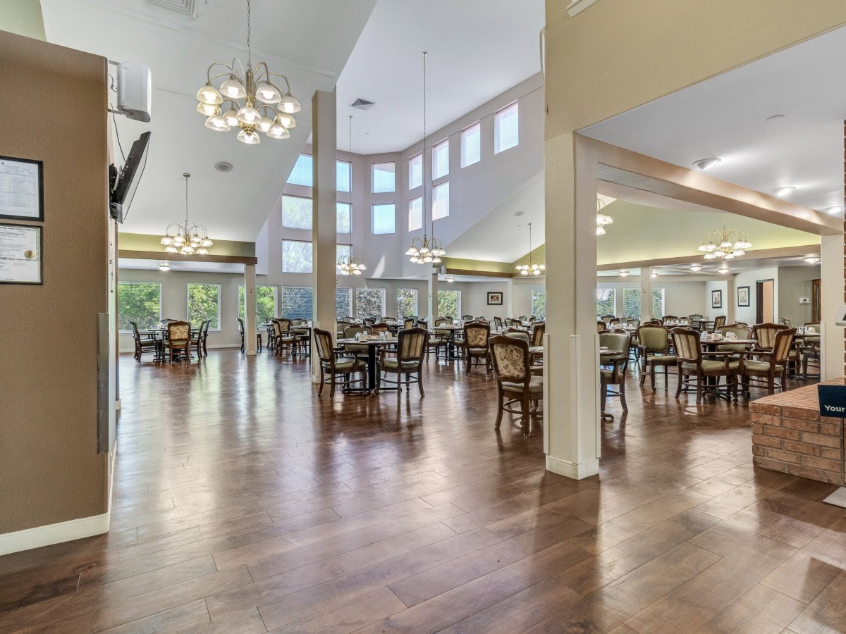 A spacious dining area with elegant lighting and wooden flooring.