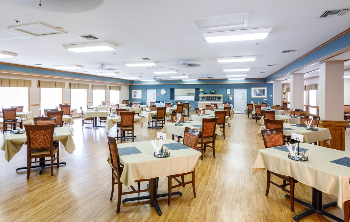 An empty dining room with neatly arranged tables and chairs.