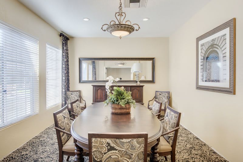 Elegant dining room with ornate chairs and a large mirror.