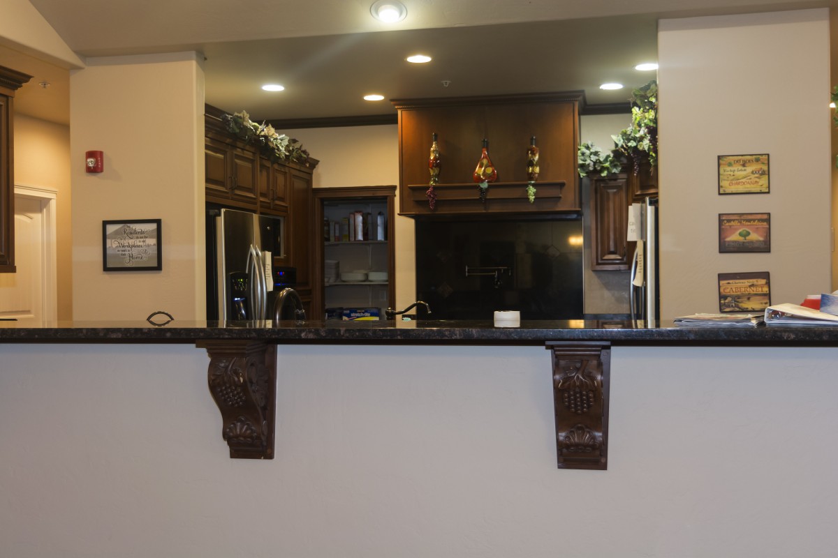 A modern kitchen with dark cabinets and a granite countertop.