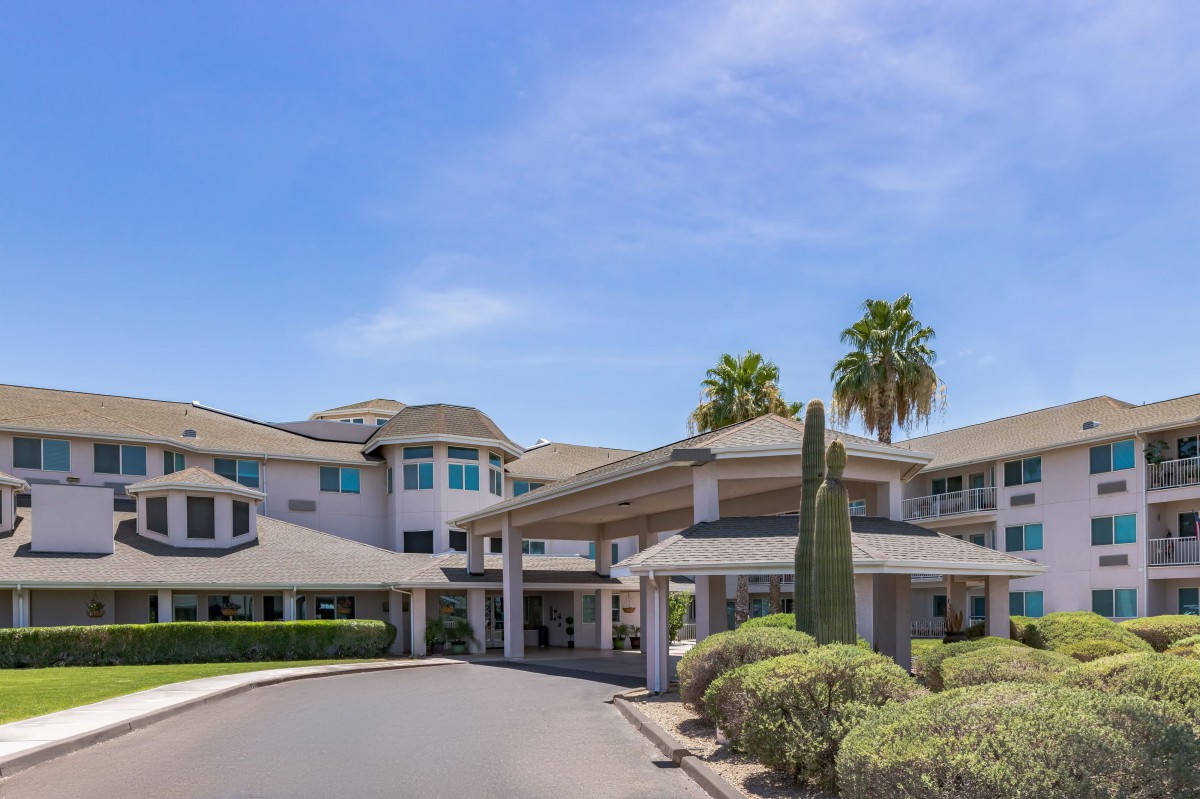 A modern building with an inviting entrance, surrounded by palm trees and well-maintained landscaping.