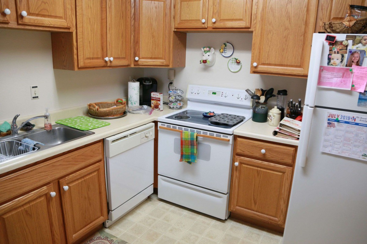 A cozy kitchen with wooden cabinets, a stove, and a dishwasher.