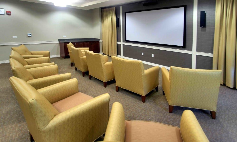 A cozy home theater setup with comfortable yellow chairs and a large projection screen.