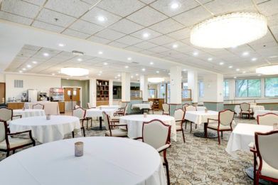 A modern and well-lit dining area with elegantly arranged tables and chairs.