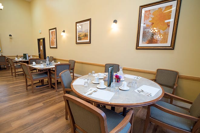 A neatly arranged dining room with tables set for a meal.