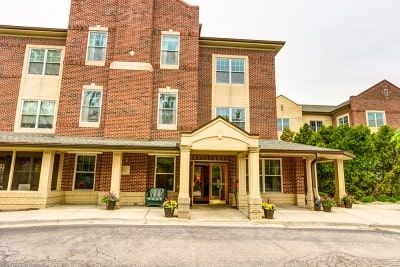 A three-story brick building with an inviting entrance and multiple windows.