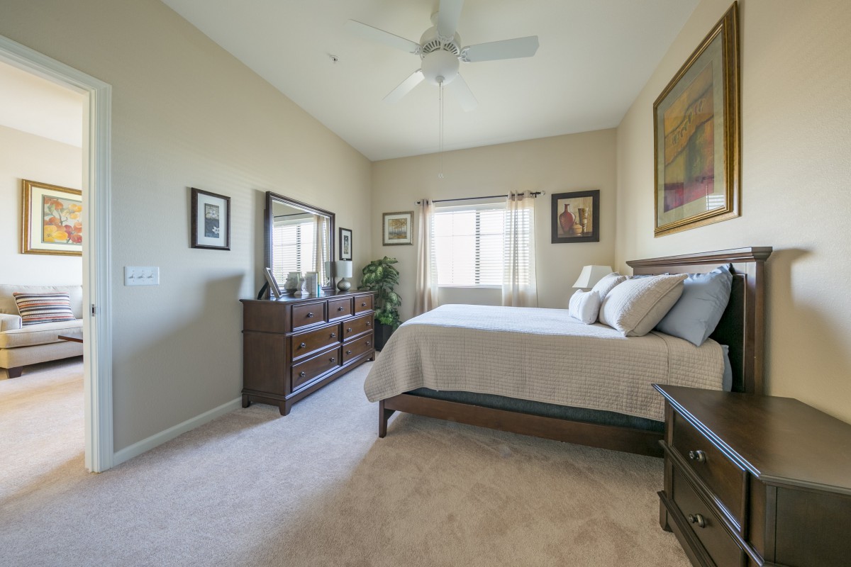 A cozy bedroom with a comfortable bed and wooden furniture.