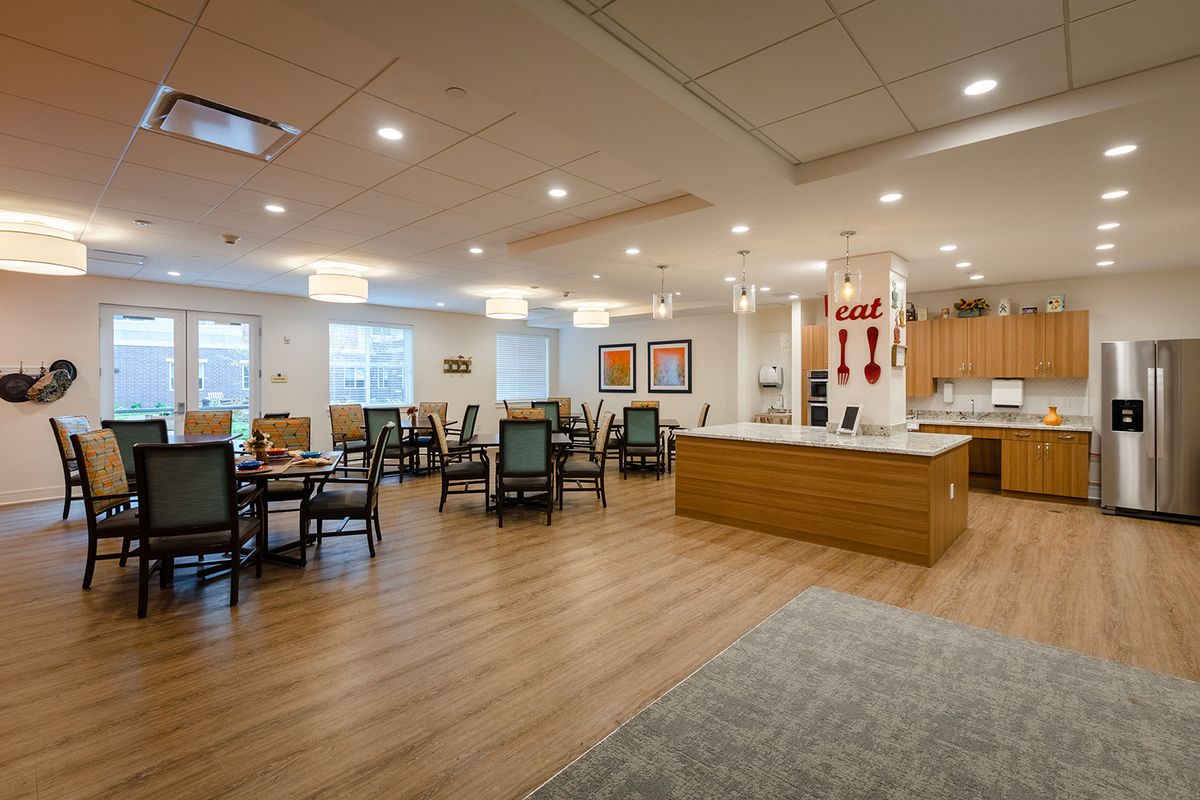 A spacious and modern dining area with wooden flooring and ample seating.