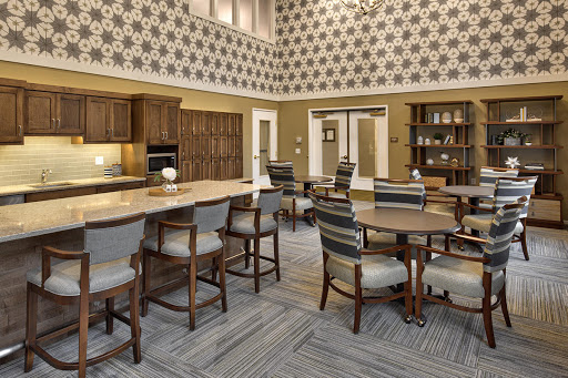 A modern common area featuring a kitchen and dining space, designed with stylish furniture and decorative walls.