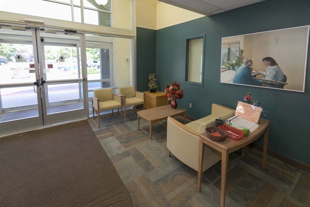 A welcoming lobby with seating and decor, featuring an entrance door and a comfortable waiting area.