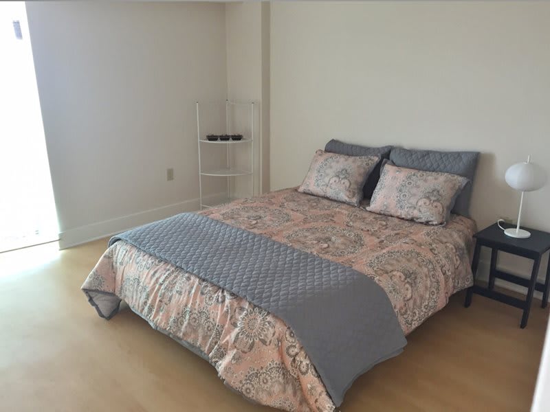 A minimalist bedroom with a neatly made bed and simple decor.