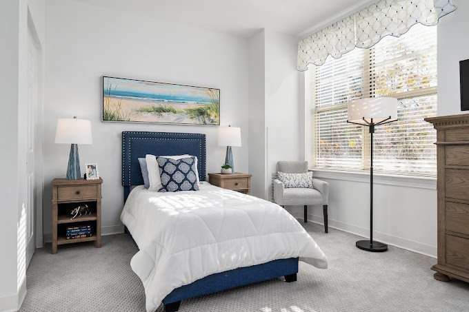 A cozy bedroom with a single bed, stylish decor, and ample natural light.