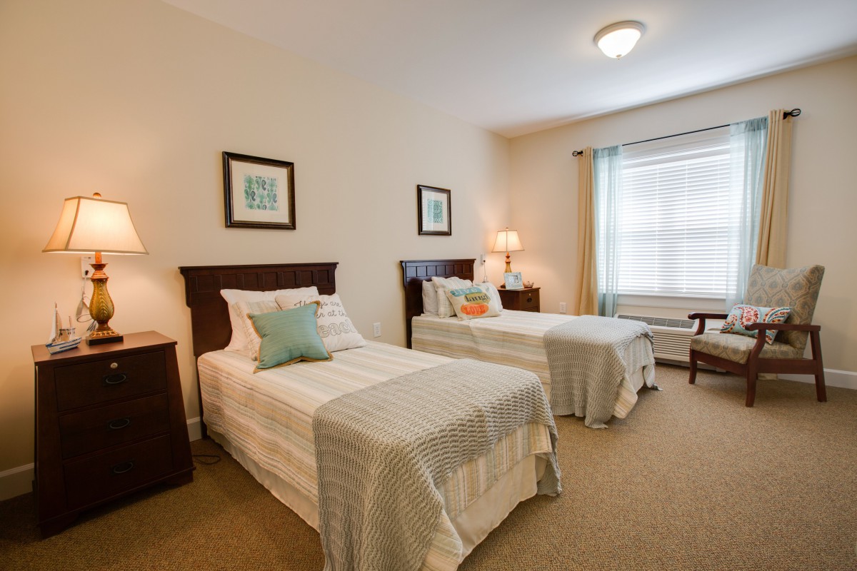 A cozy bedroom with twin beds and a bright window.