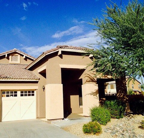 A suburban house with a desert landscape in the front yard.