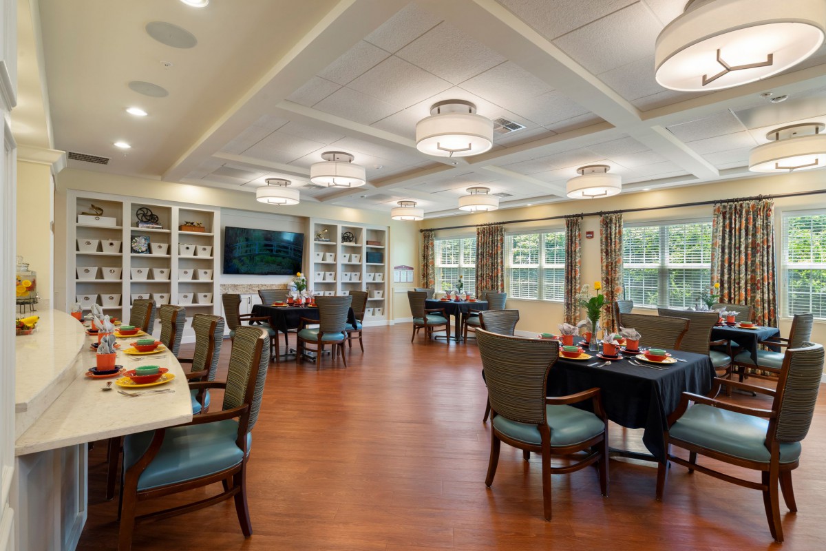 A spacious and elegant dining room with modern furnishings and ample lighting.