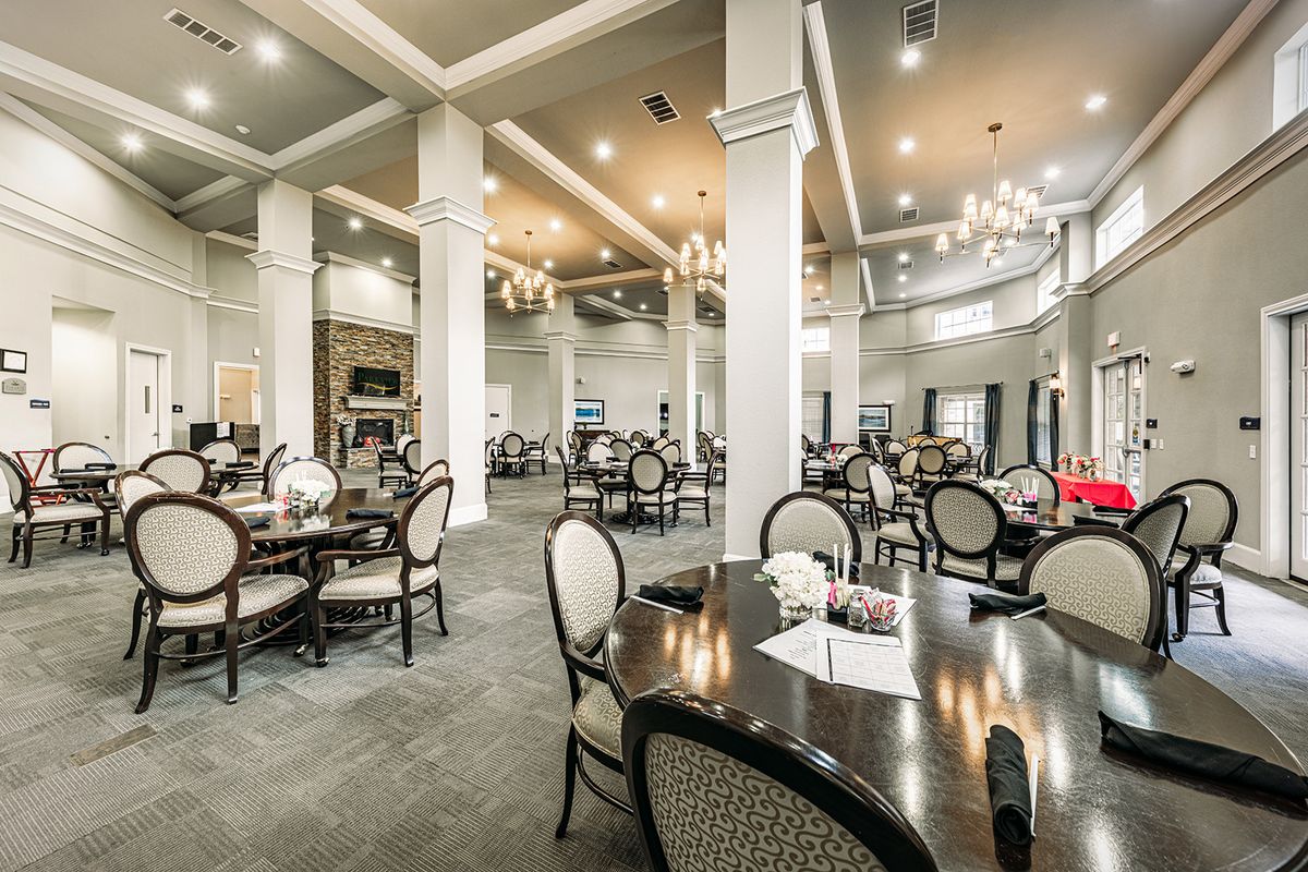 An elegant dining area with tables and chandeliers in a spacious restaurant setting.