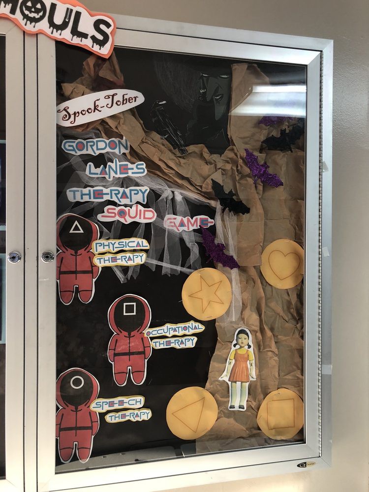 A bulletin board display featuring Halloween and Squid Game-themed decorations.