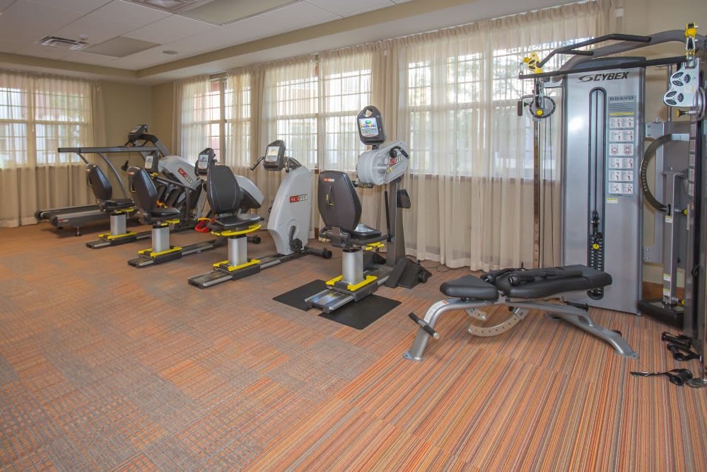 A well-equipped gym with various exercise machines arranged neatly in a spacious room.