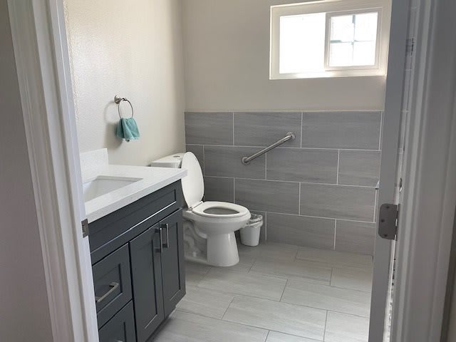 A clean and bright bathroom with a toilet, sink, and towel rack.