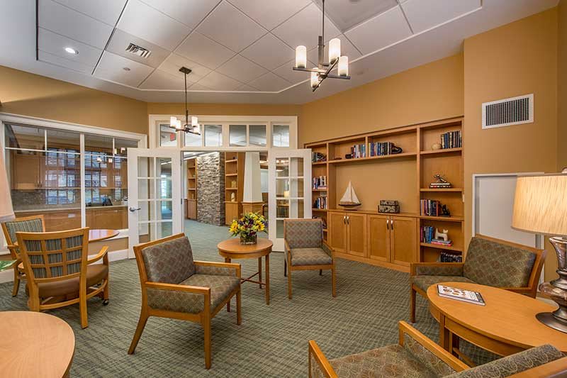 A cozy library interior with seating and bookshelves.