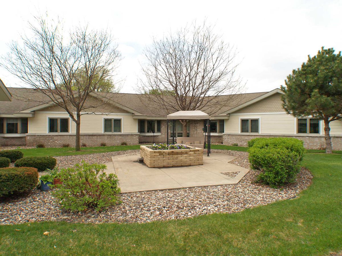 A residential building with well-maintained landscaping and a fountain in the front yard.