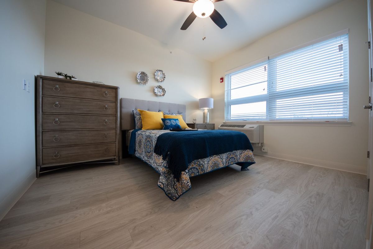 Cozy bedroom with modern decor and ample natural light from large windows.