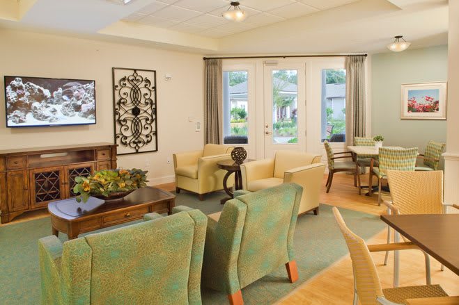 A cozy living room with comfortable seating and large windows overlooking a garden.