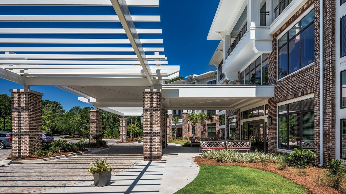 Modern architectural design featuring a pergola with brick pillars and open outdoor spaces.