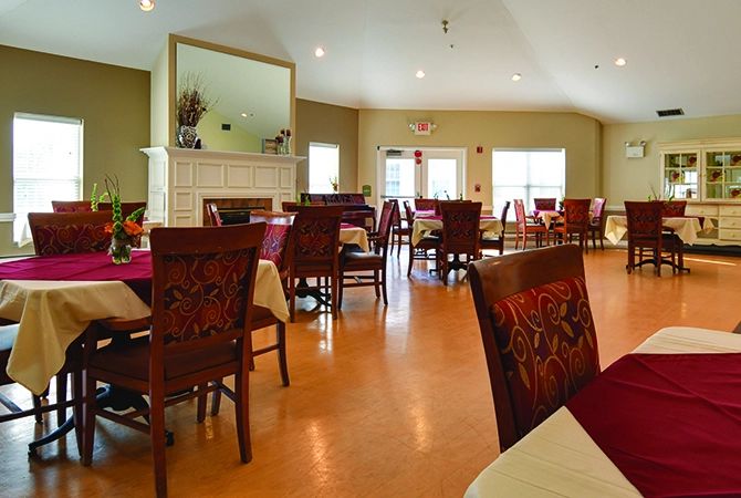 A spacious dining room with neatly arranged tables and chairs, featuring elegant decor.
