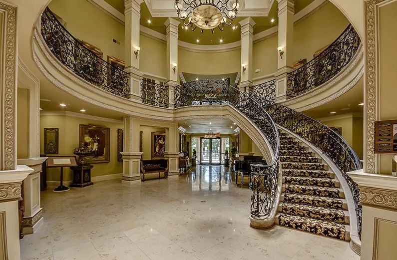 A luxurious interior with a grand staircase and chandelier.